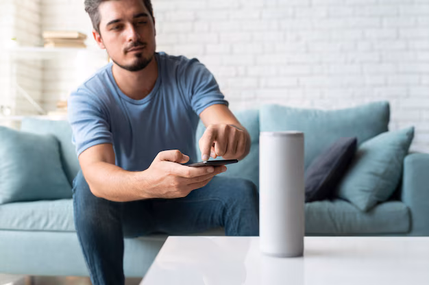 Person talking to smart speaker in living room - Man using a speaker digital assistant | Free Photo