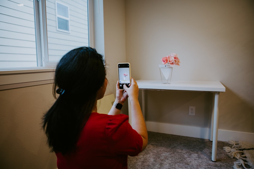 Person frustrated with smart home device - woman in red long sleeve shirt holding silver iphone 6